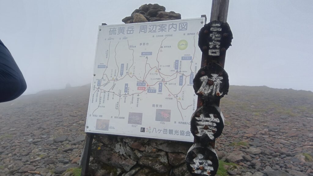 霧に包まれた硫黄岳山頂付近の案内図と山頂標識