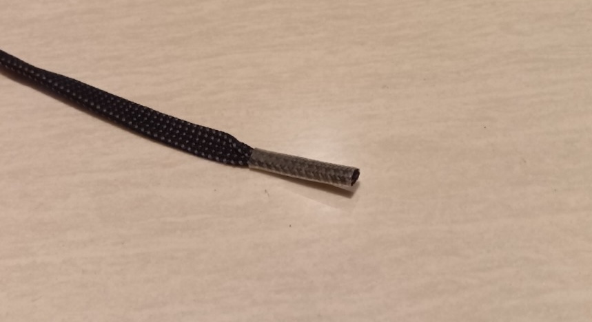 長い靴ひもを踏み、先端のアグレットが外れて修理した状態